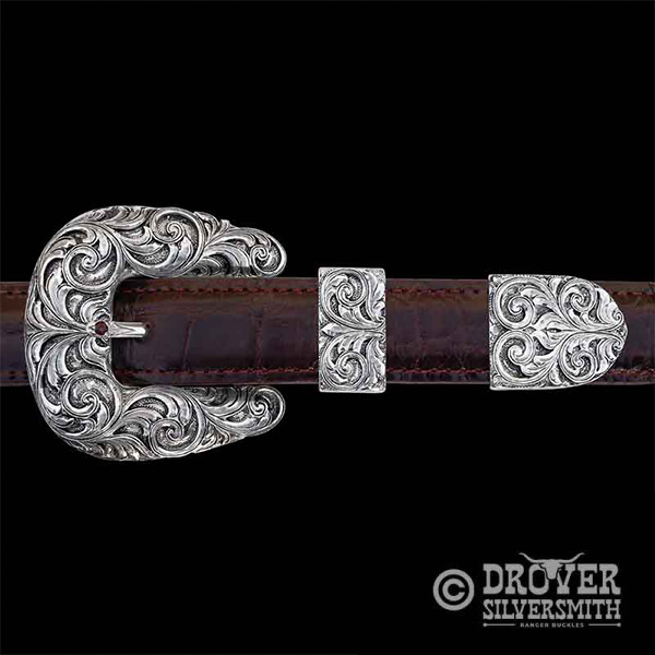This three piece belt buckle set is built on a Solid Sterling Silver base with Solid Sterling Silver scroll work set on top of it. So class it up, Cowboy!